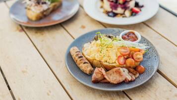 A wooden table with three plates of food.