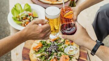 A wooden table with two pizzas and a salad.