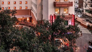 Un hôtel à étages, doté de balcons et d’une entrée bien éclairée.