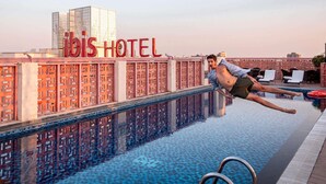 Un homme plonge dans une piscine à l’hôtel Ibis.
