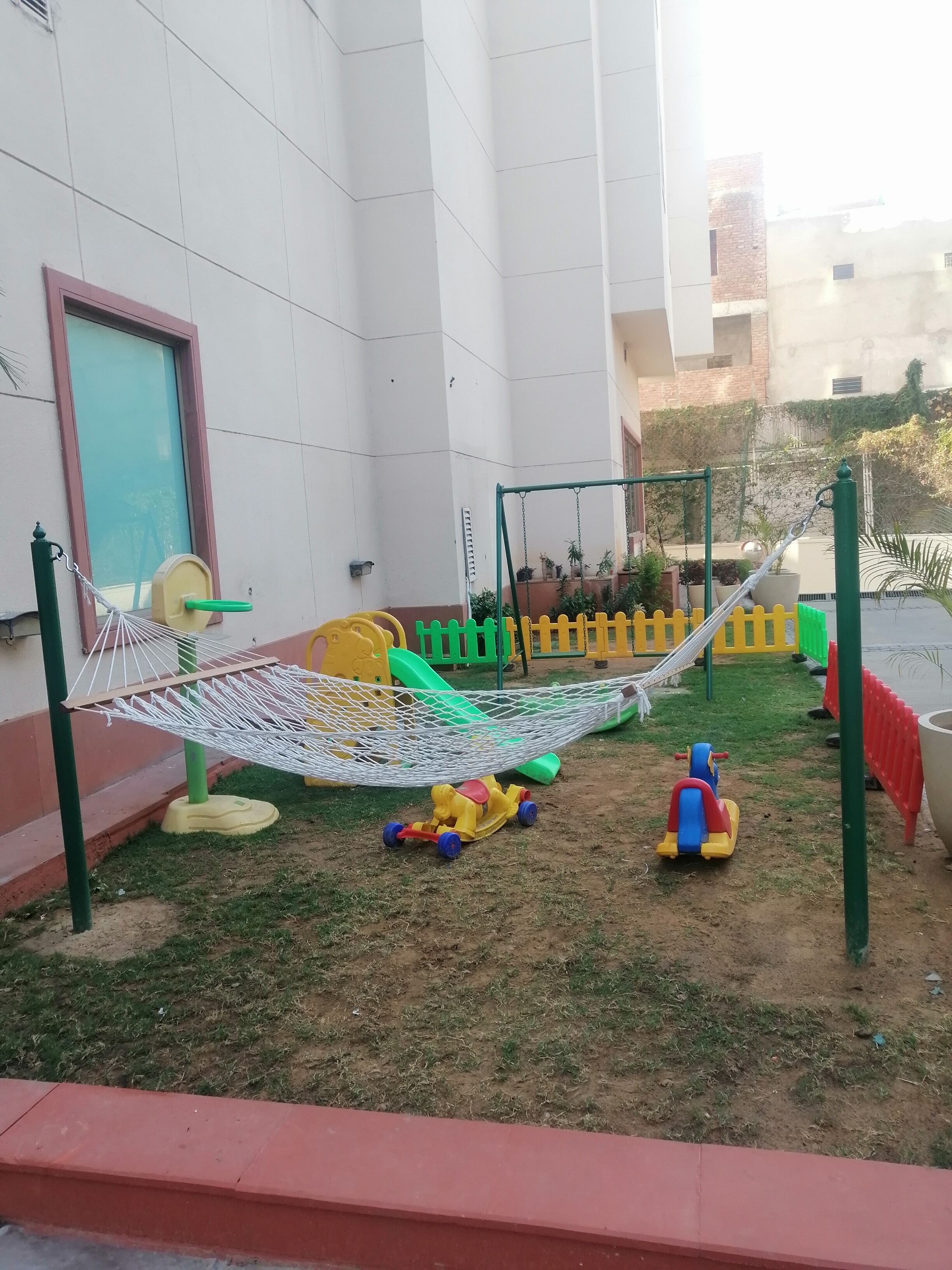 A children's play area with a hammock, play structures, and toys.
