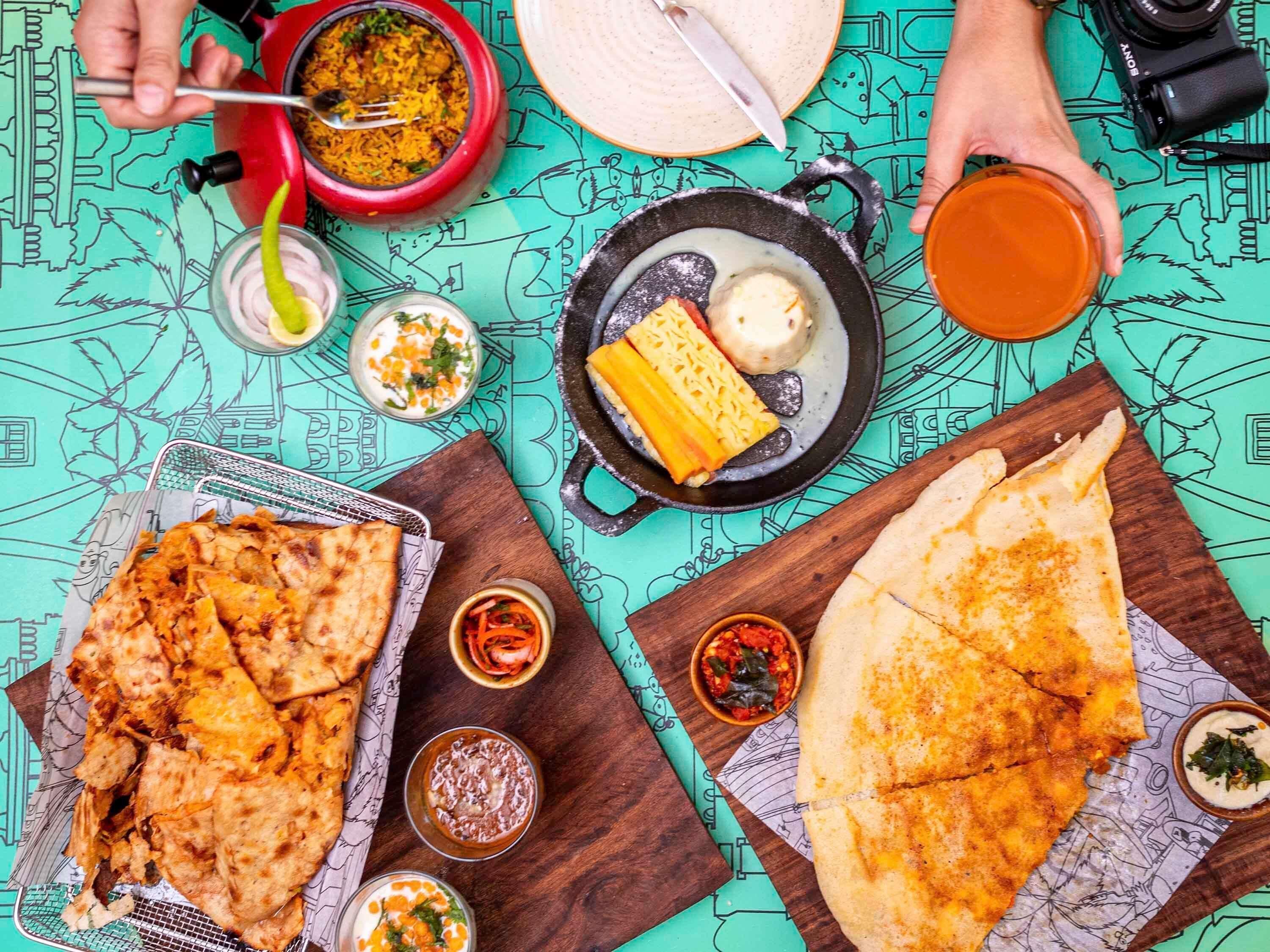 Una mesa con diversos platos, entre ellos, pan plano, un cuenco de arroz y una taza de té.