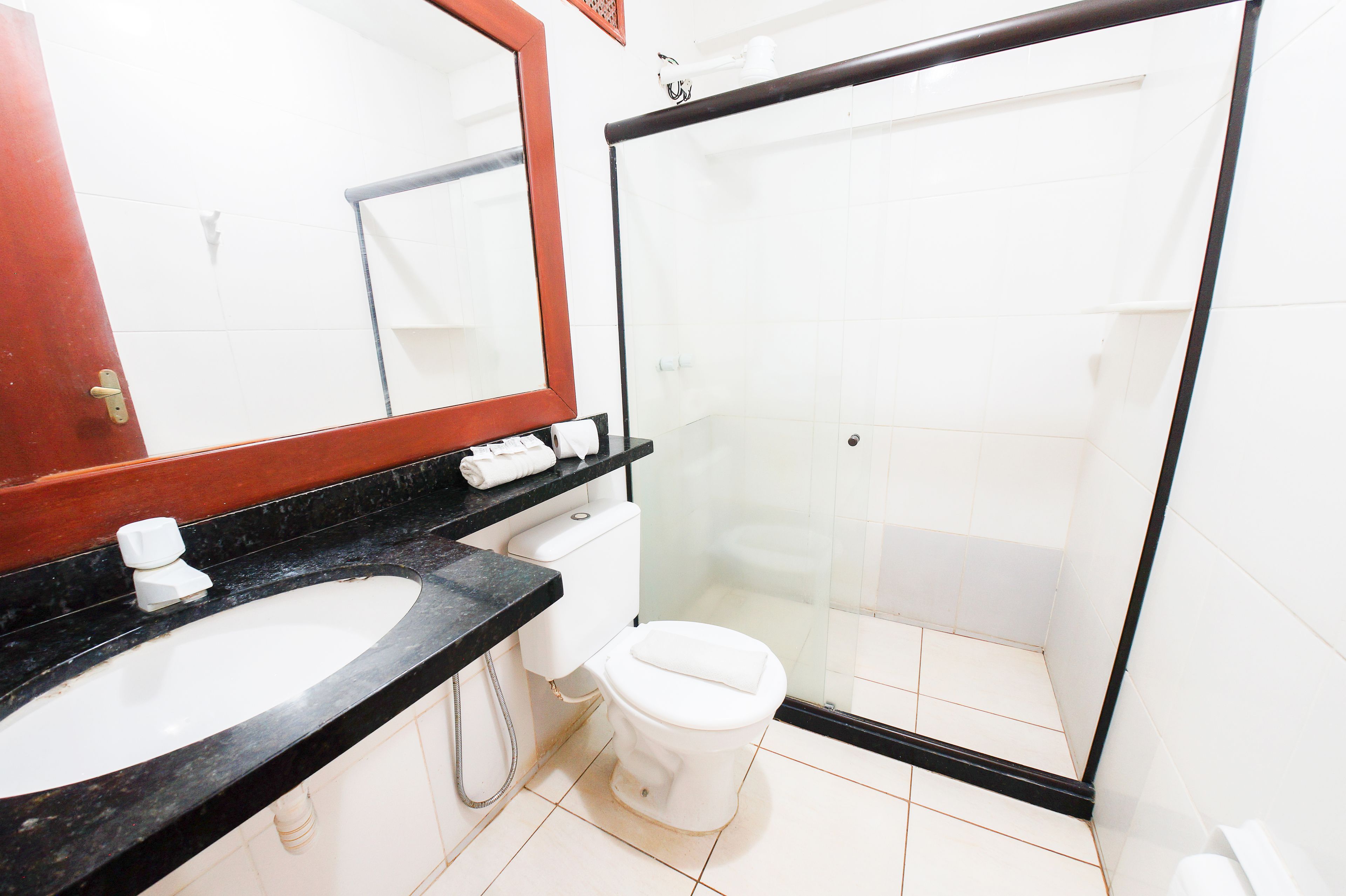 A bathroom with a sink, toilet, and glass shower enclosure.