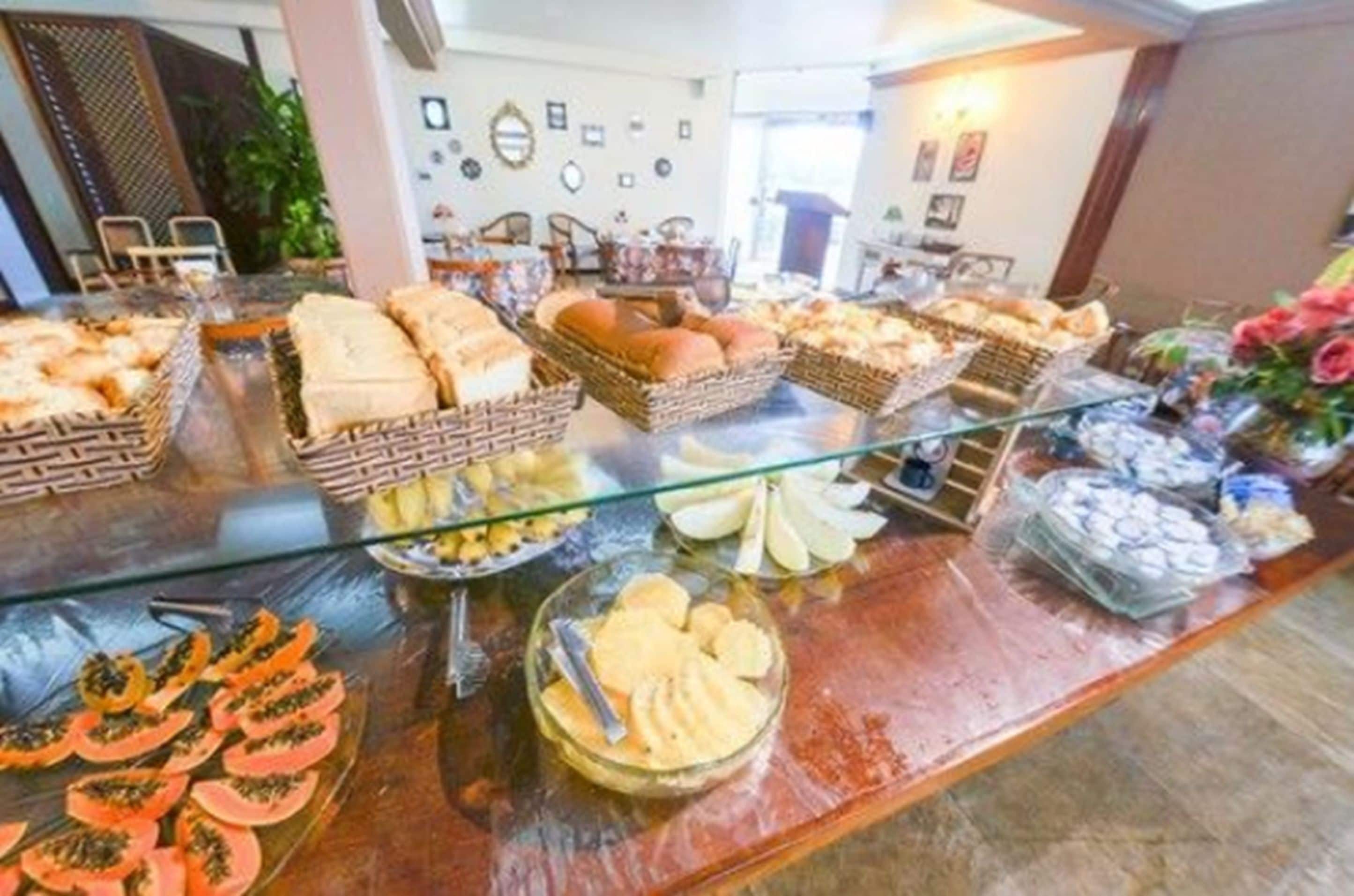 En buffet med forskellige spisemuligheder, heriblandt brød, kager og frugt.