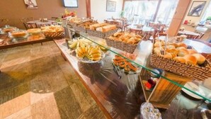 Montaje de bufé con diversos alimentos como pan, pasteles y frutas.