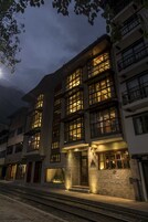 Un hotel de varios pisos con ventanas iluminadas y fachada de piedra.