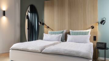 Un dormitorio moderno con una cama grande, un cabecero de listones de madera y dos lámparas de noche.