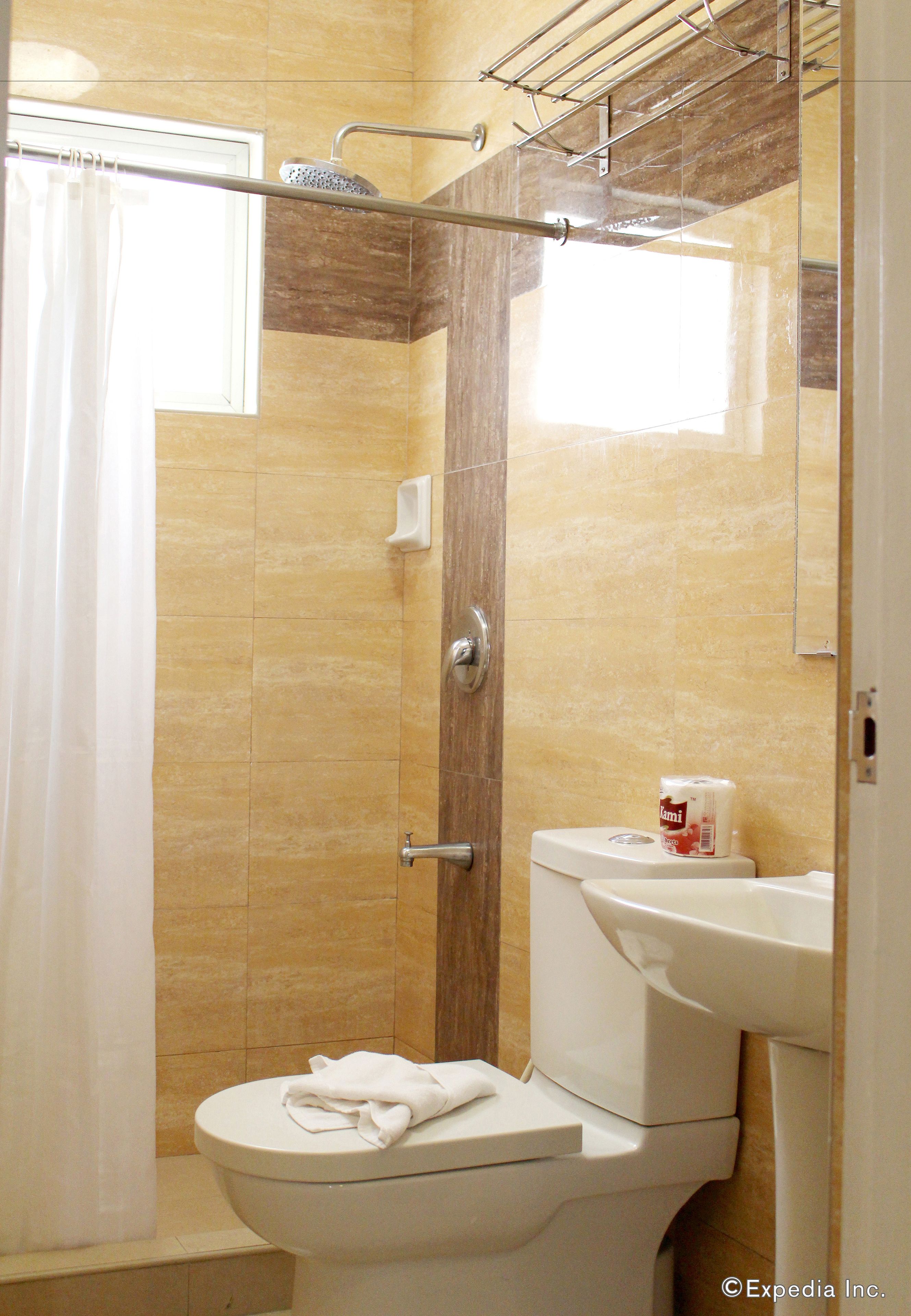 A bathroom with a shower, toilet, and sink.