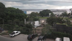 Un estacionamiento con varios vehículos, incluyendo una camioneta pickup blanca y un SUV negro.