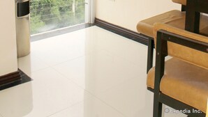 A room with a large window, a chair, and a trash bin. - Devera Hotel (Angeles City)