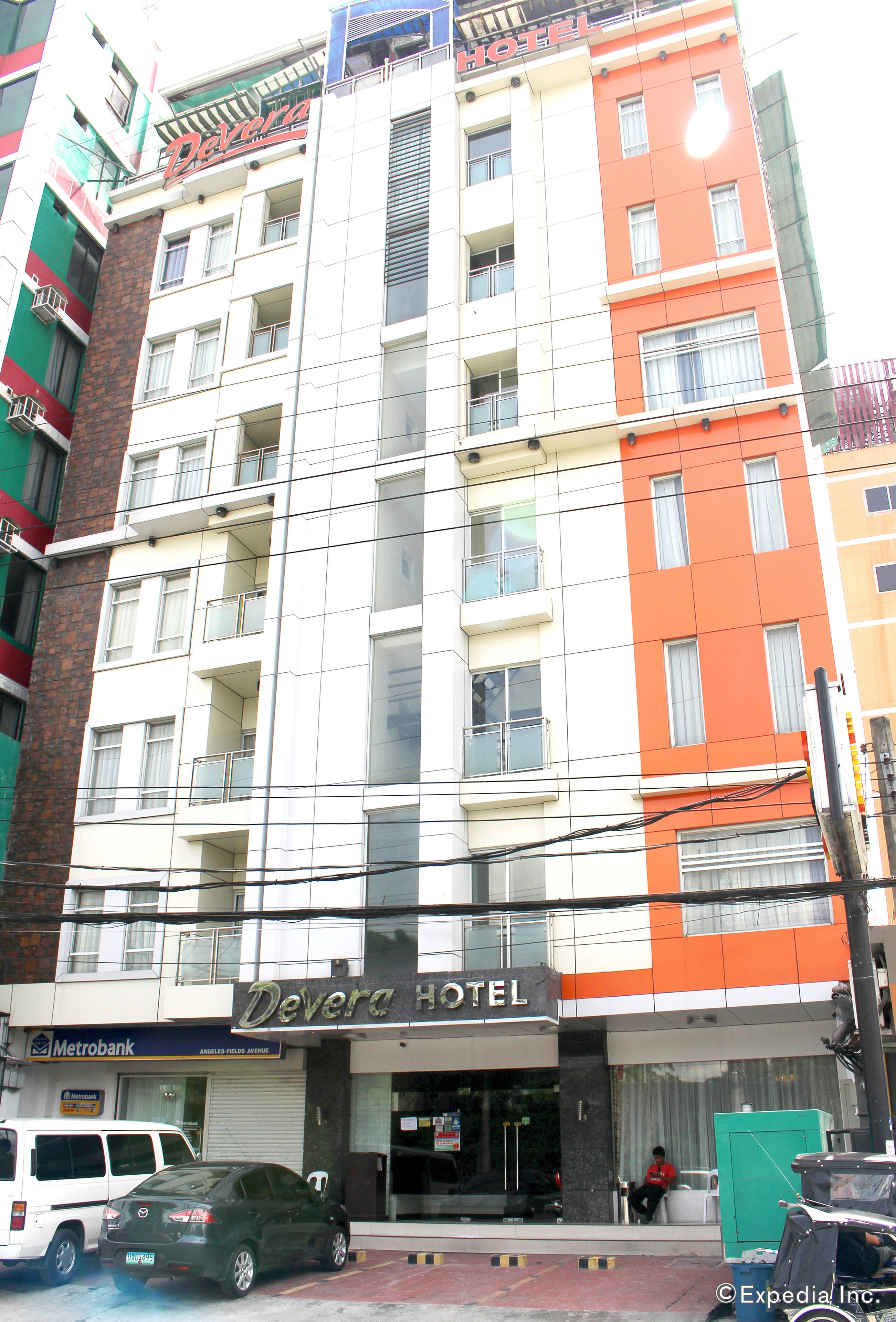 Ein mehrstöckiges Hotel mit Balkonen, einem sichtbaren Eingang und einem Metrobank-Schild.