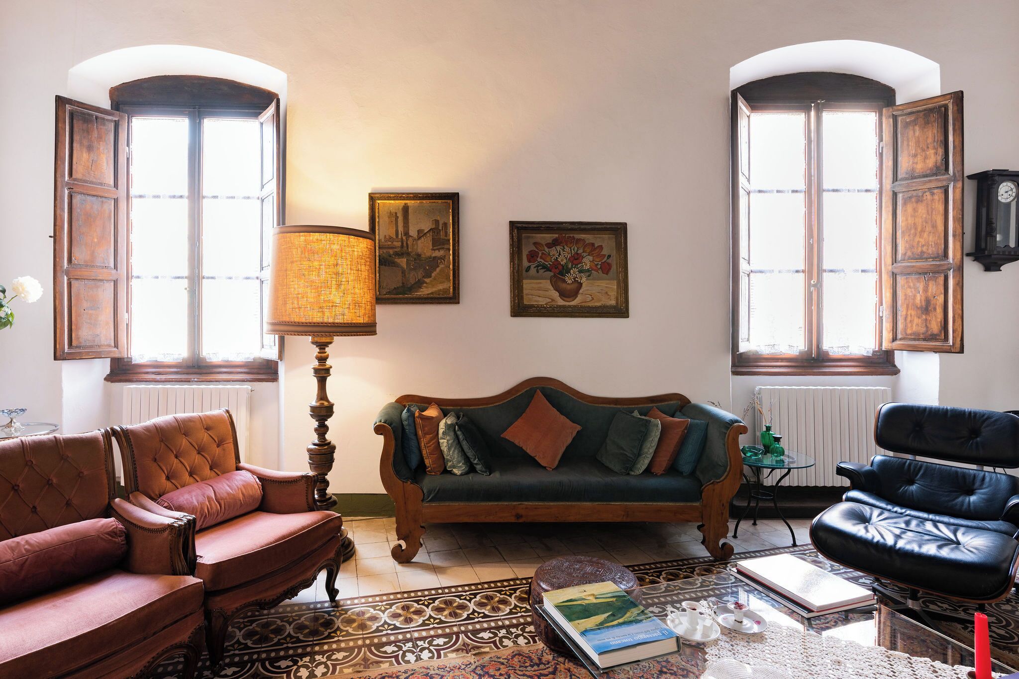 Ein Wohnzimmer mit Sofa, Sesseln, einer Lampe, einem Couchtisch und einem Kamin.