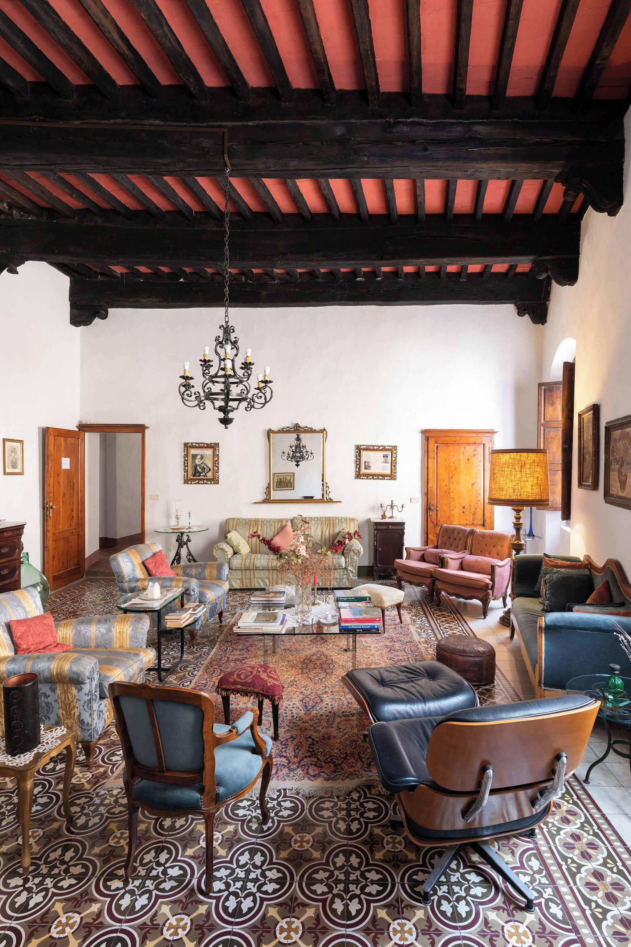A traditional room with a patterned floor, wooden furniture, and a chandelier.