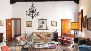 A traditional room with a patterned floor, wooden furniture, and a chandelier.