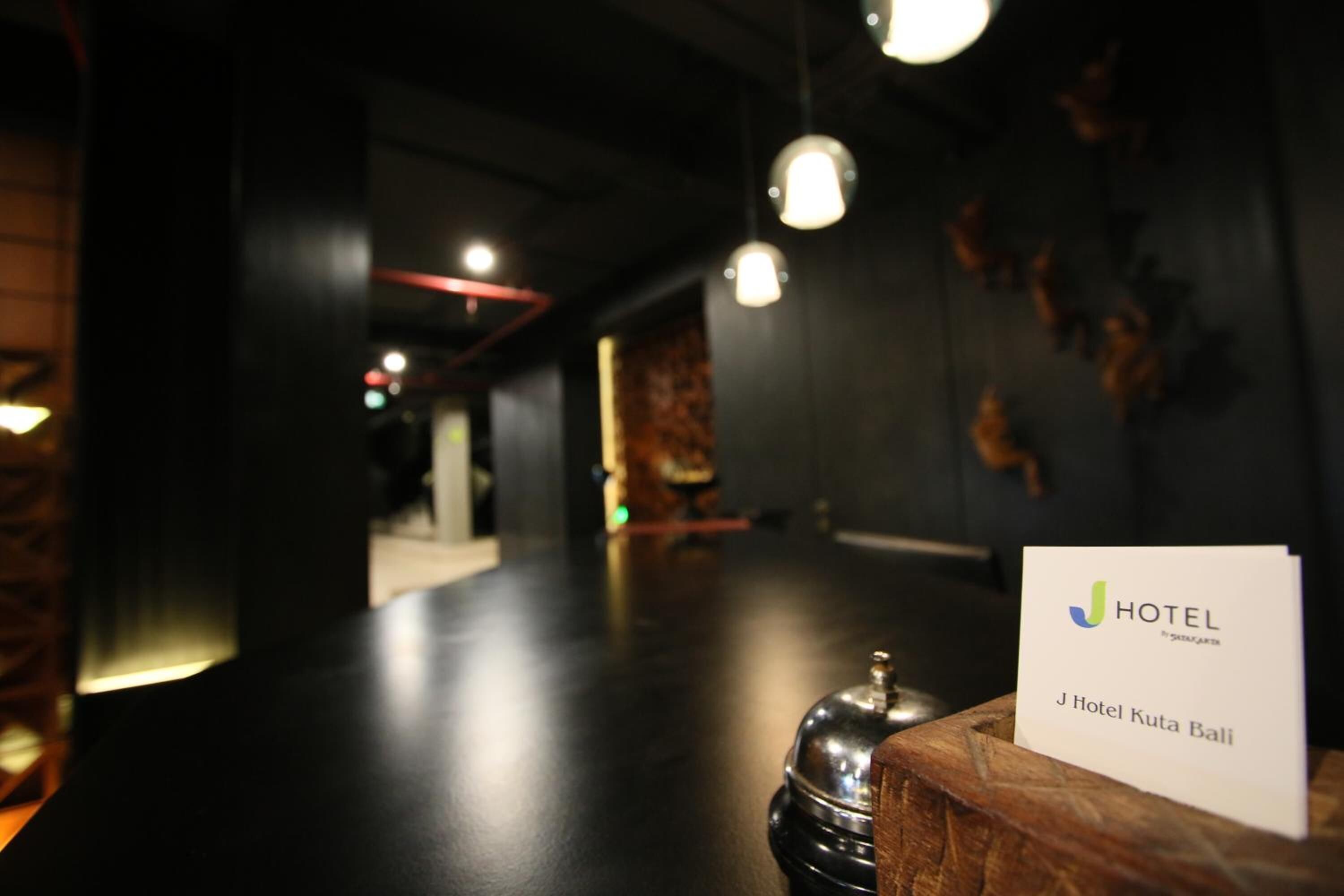 A reception area with a sign for J Hotel Kota Bali.