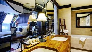 Habitación de hotel moderna con tocador de madera, dos lavamanos, un espejo grande y una cama con vista a la ciudad.