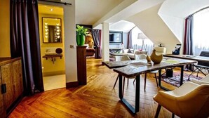 Um interior moderno com piso de madeira, uma mesa de jantar com cadeiras, um espelho grande e uma planta.