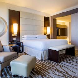 Relax in a spacious room with a large bed, comfortable armchair, and wall-mounted TV.