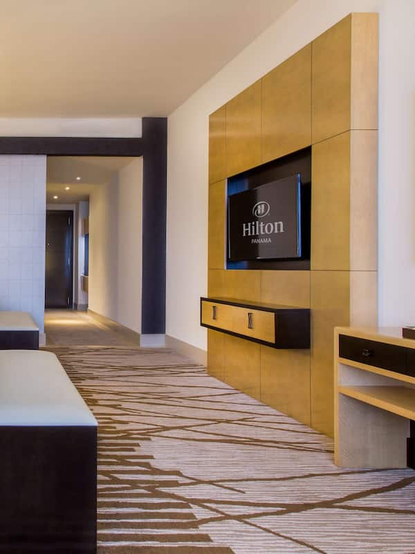 Relax in a spacious room with a large bed, flat-screen TV, and convenient bedside table.