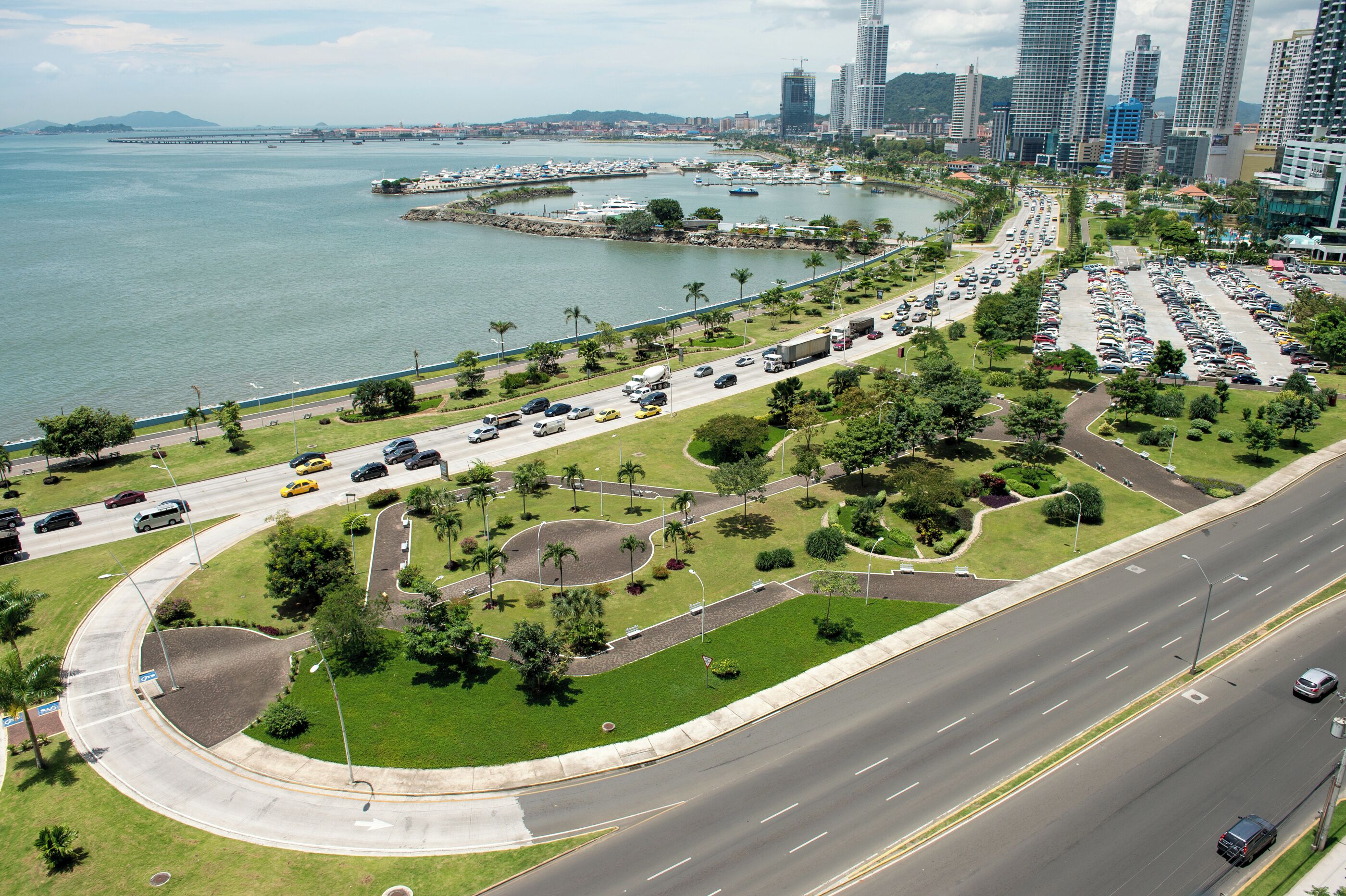 Une vue urbaine comprenant un port de plaisance, une route sinueuse et un parking.