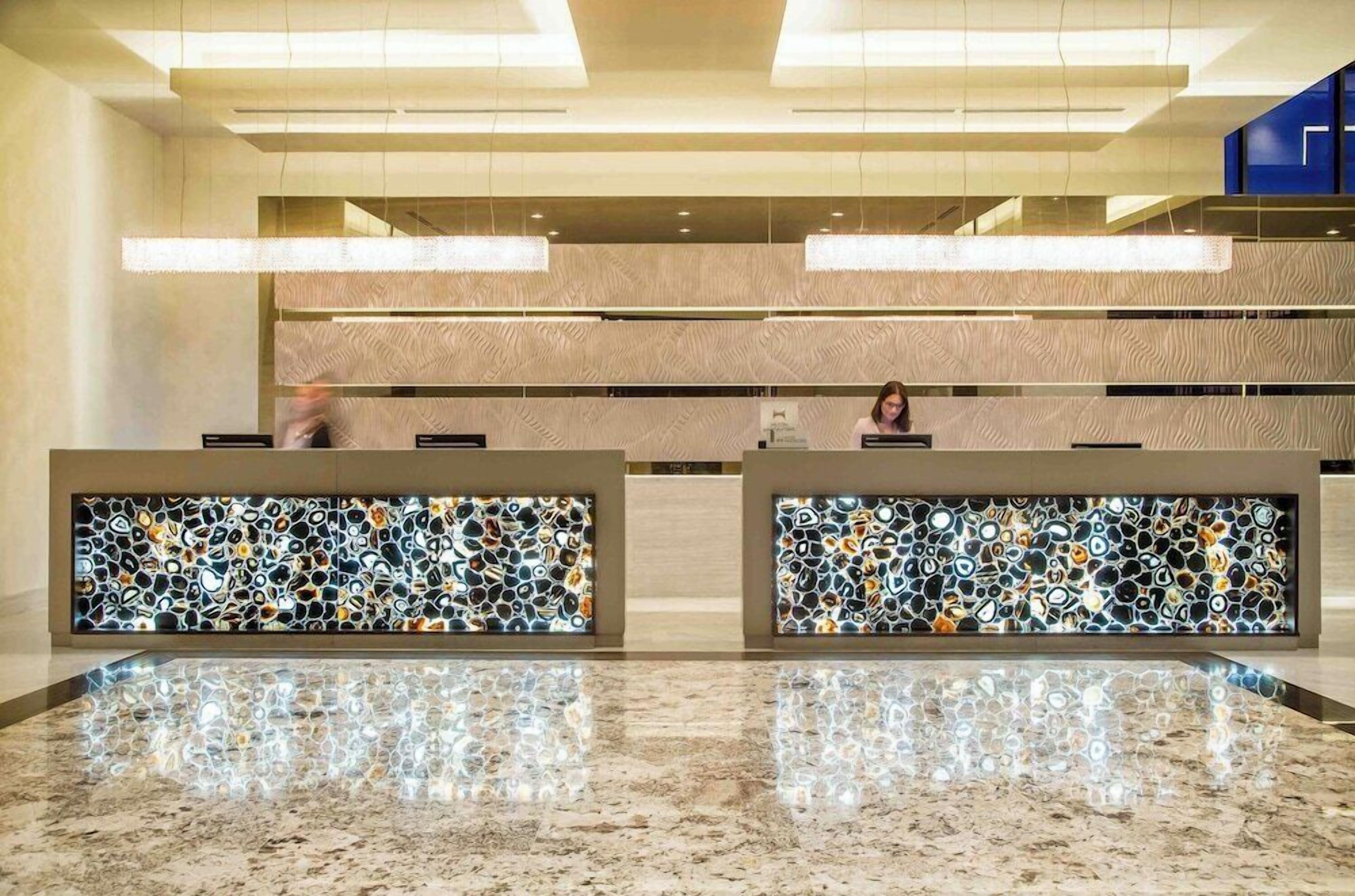 A reception area with two counters, a marble floor, and a patterned wall.