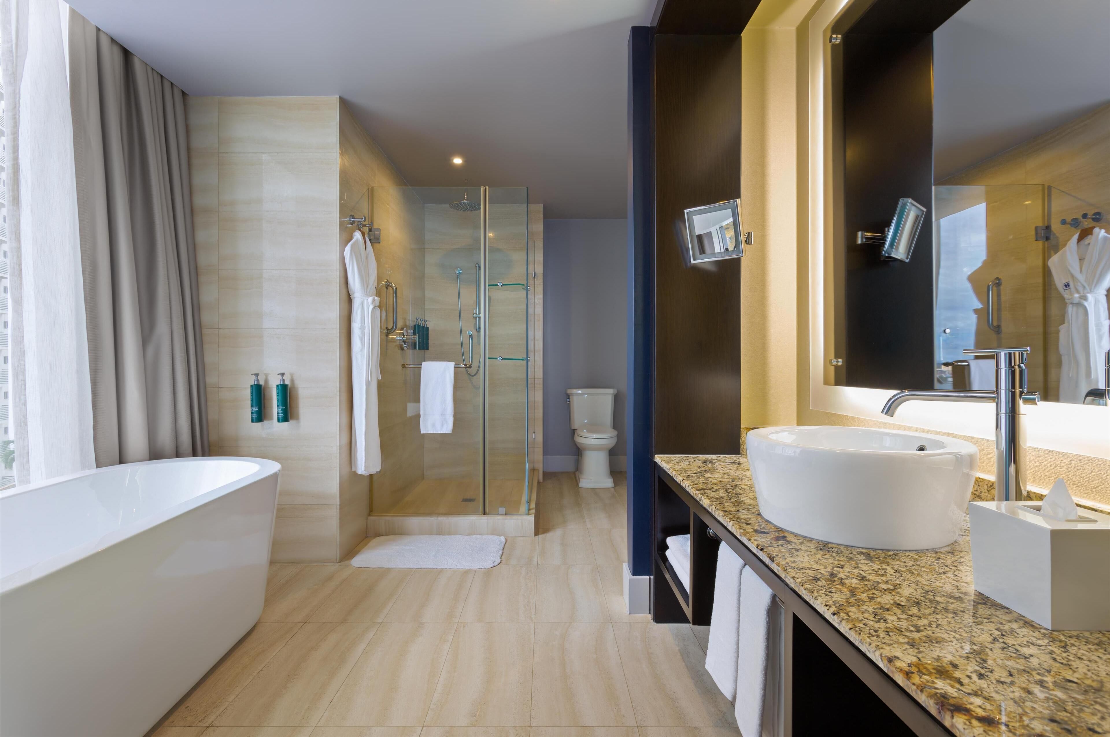 A modern bathroom with a freestanding bathtub, a glass-enclosed shower, and a vanity with a sink and mirror.
