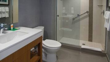 A modern bathroom with a white sink, toilet, and glass-enclosed shower.