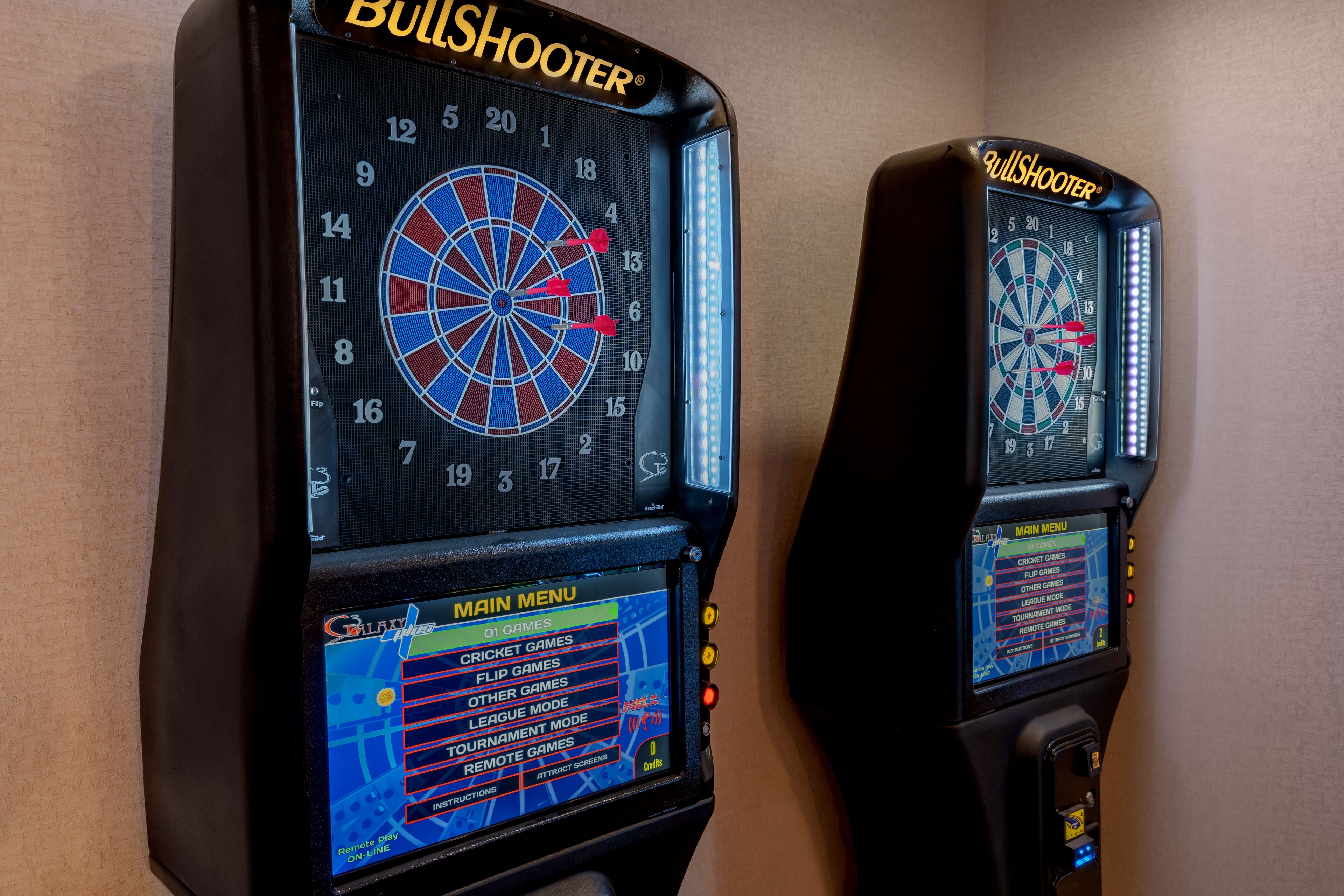 Two BullShooter dartboards with digital score displays and a main menu for game selection.