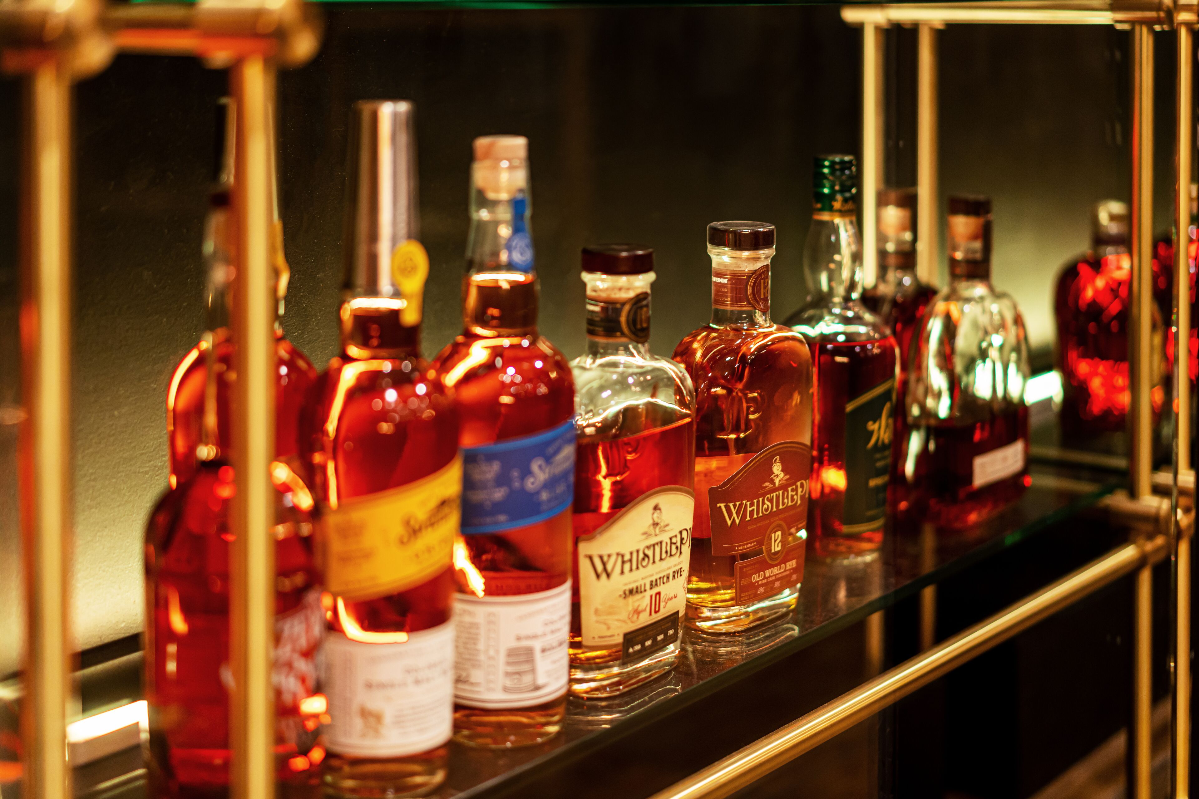 A variety of liquor bottles on a shelf.