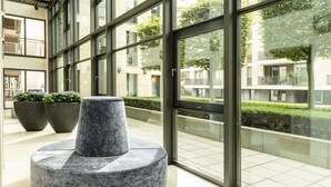 Moderni sisätila, jossa on suuret ikkunat, pyöreä oleskelualue ja ruukkukasveja.
