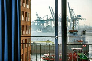 A view of a port with cranes and a ship named "Tarzan" docked. - Clipper Boardinghouse – Hamburg-Holzhafen (Hamburg)