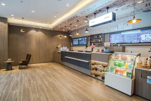 A modern reception area with a wooden floor, a reception desk, a coffee station, and a digital menu display. - HanTing Hotel (Shenzhen Huaqiangbei Yannan Subway Station) (Shenzhen)
