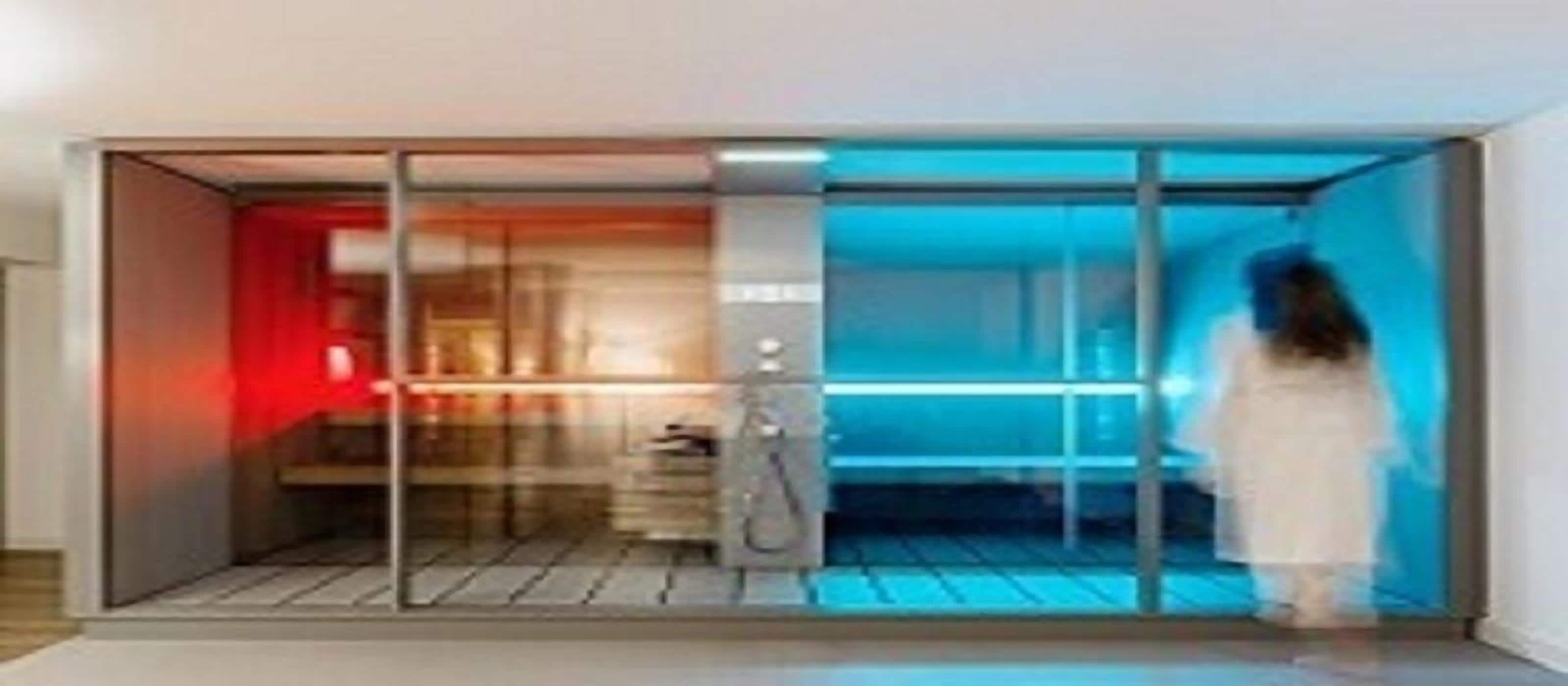 Een moderne hotelkamer met een schuifglasdeur naar een balkon, een ingebouwd bureau en een groot raam.