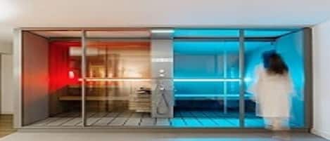 A modern hotel room with a sliding glass door leading to a balcony, a built-in desk, and a large window.