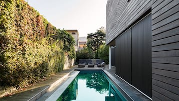 Una piscina al aire libre de temporada, sillones reclinables de piscina