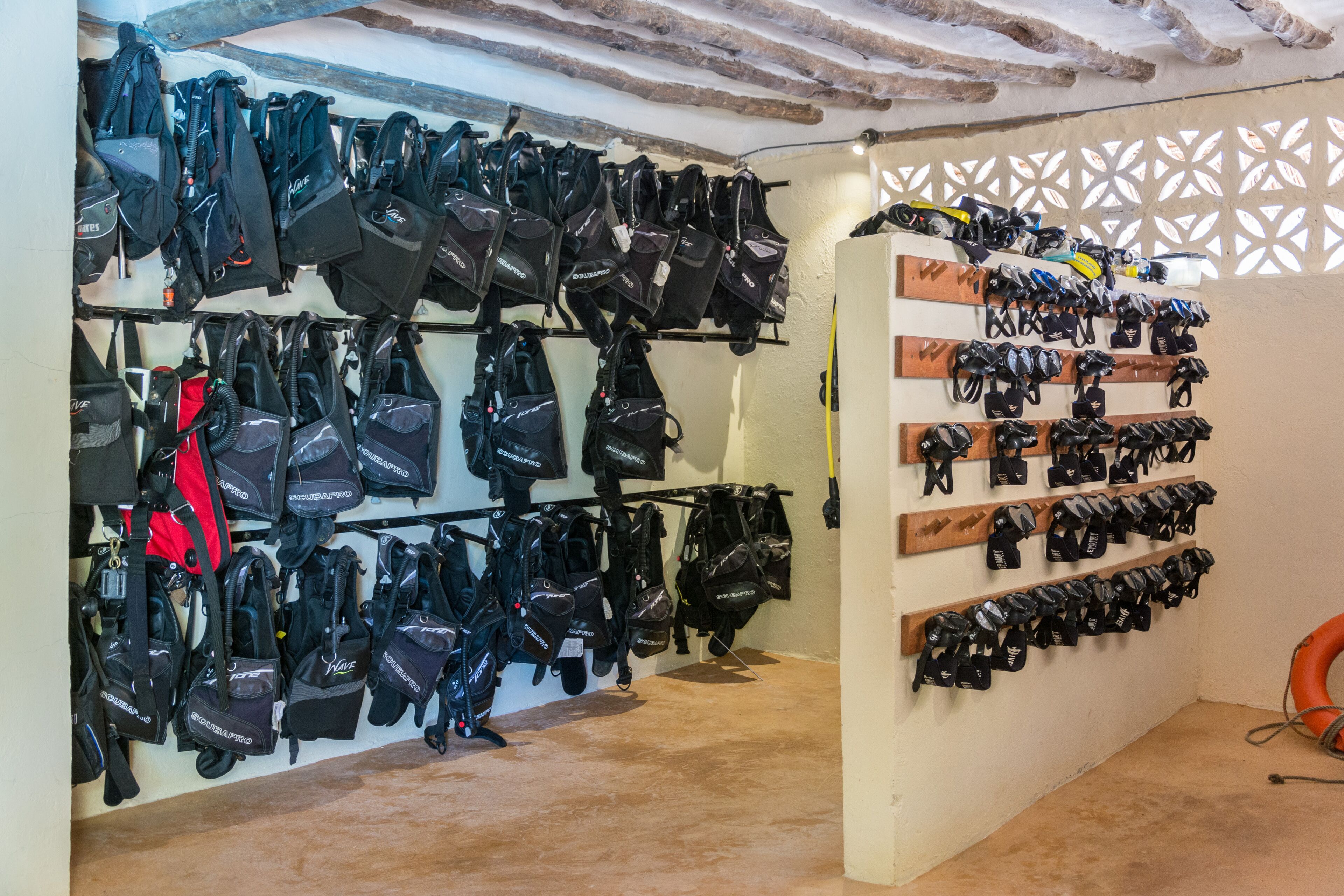 Una pared con varias filas de bolsas negras colgadas en estanterías.