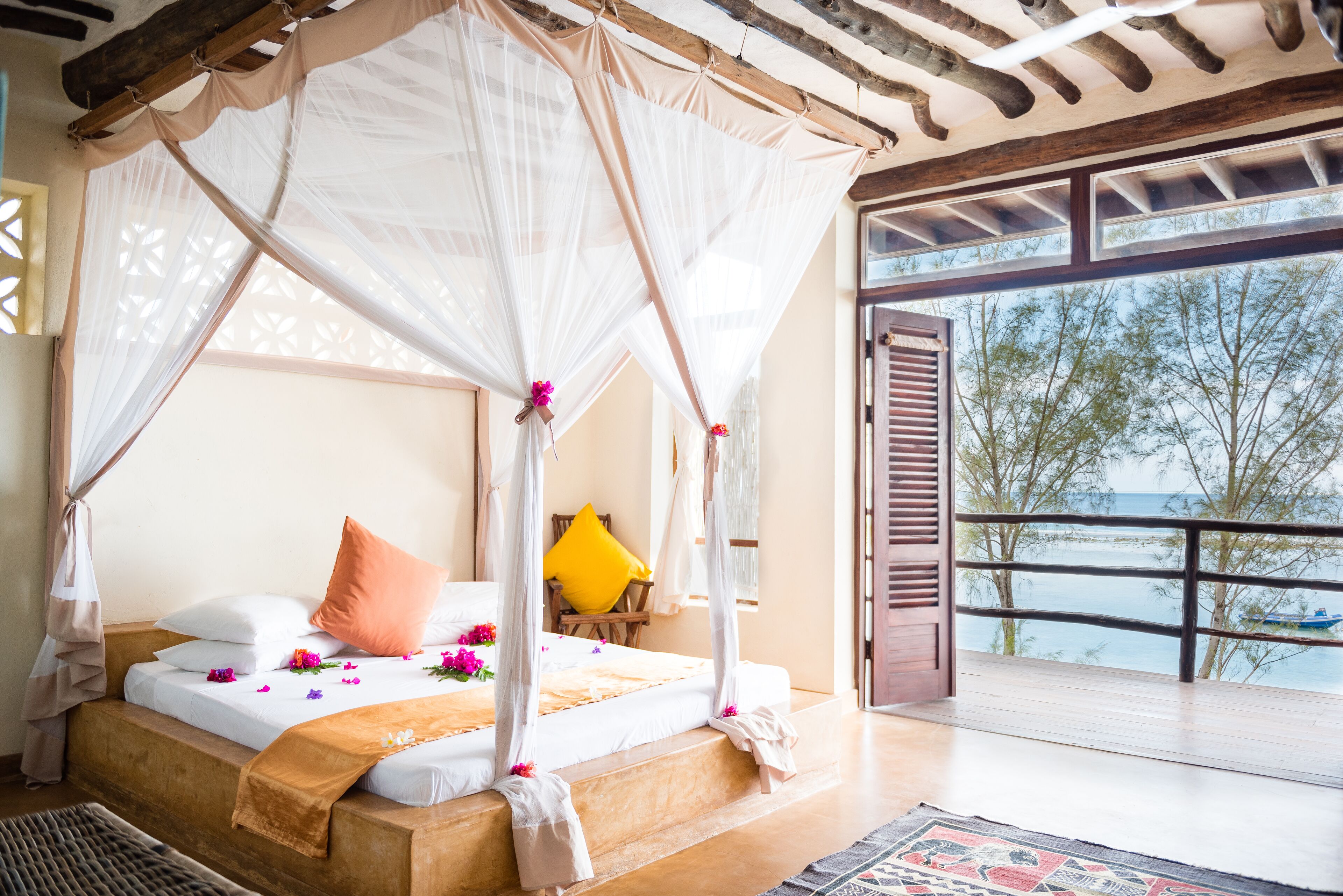 Ein Schlafzimmer mit Himmelbett, Meerblick und einem Balkon.