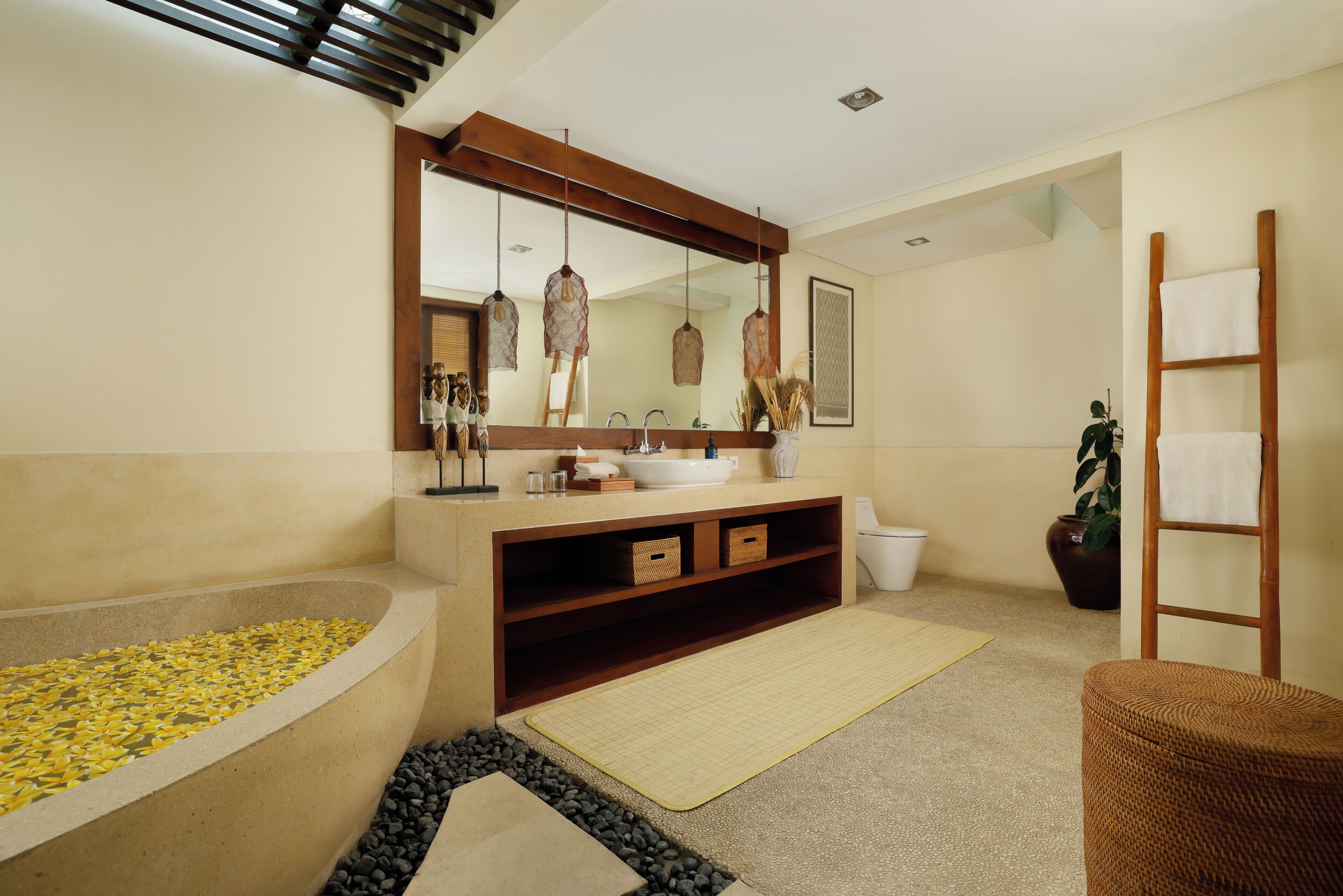 A modern bathroom with a large bathtub, a wooden vanity, a large mirror, and a potted plant.
