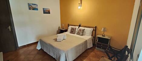 A neatly made bed with white linens, two bedside tables with lamps, and a wall-mounted light fixture.