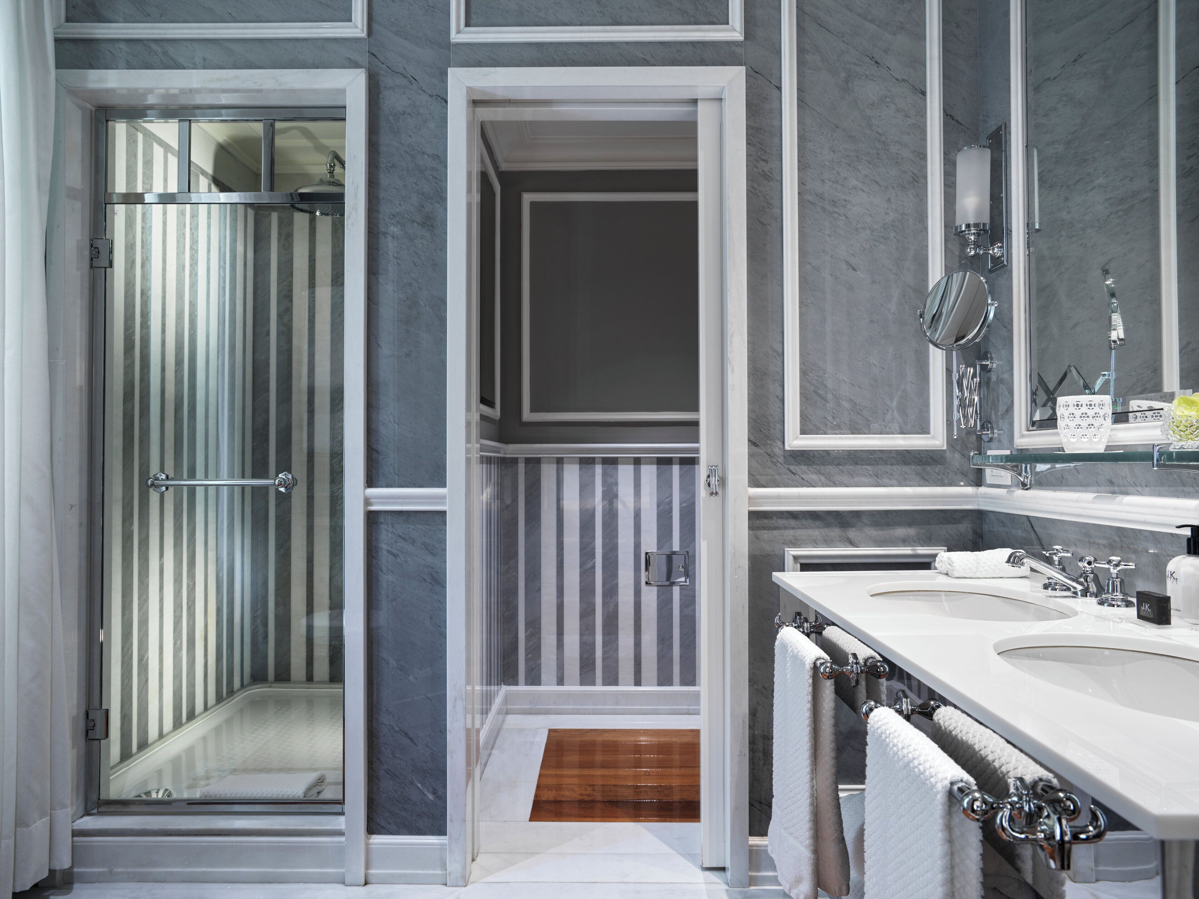 Een moderne badkamer met een douchecabine van glas, een wastafelmeubel met spiegel en een wastafel.