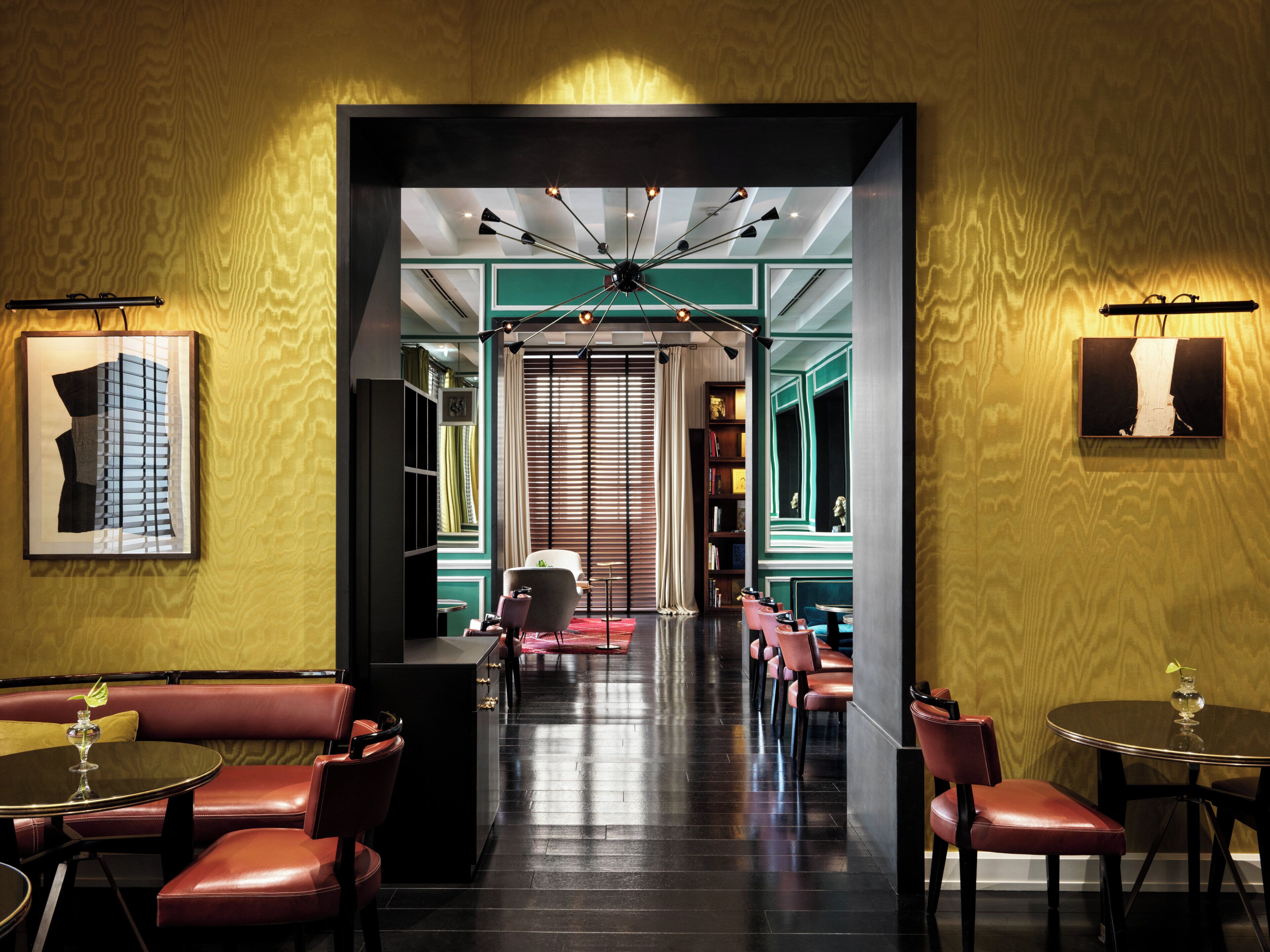 A modern interior with a central hallway, seating areas, and a ceiling light fixture.