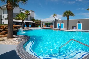 A swimming pool with a hot tub, palm trees, and a covered seating area. - TownePlace Suites by Marriott Galveston Island (Galveston)