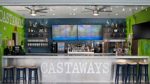 A bar area with a counter, multiple stools, and a menu board. - TownePlace Suites by Marriott Galveston Island (Galveston)