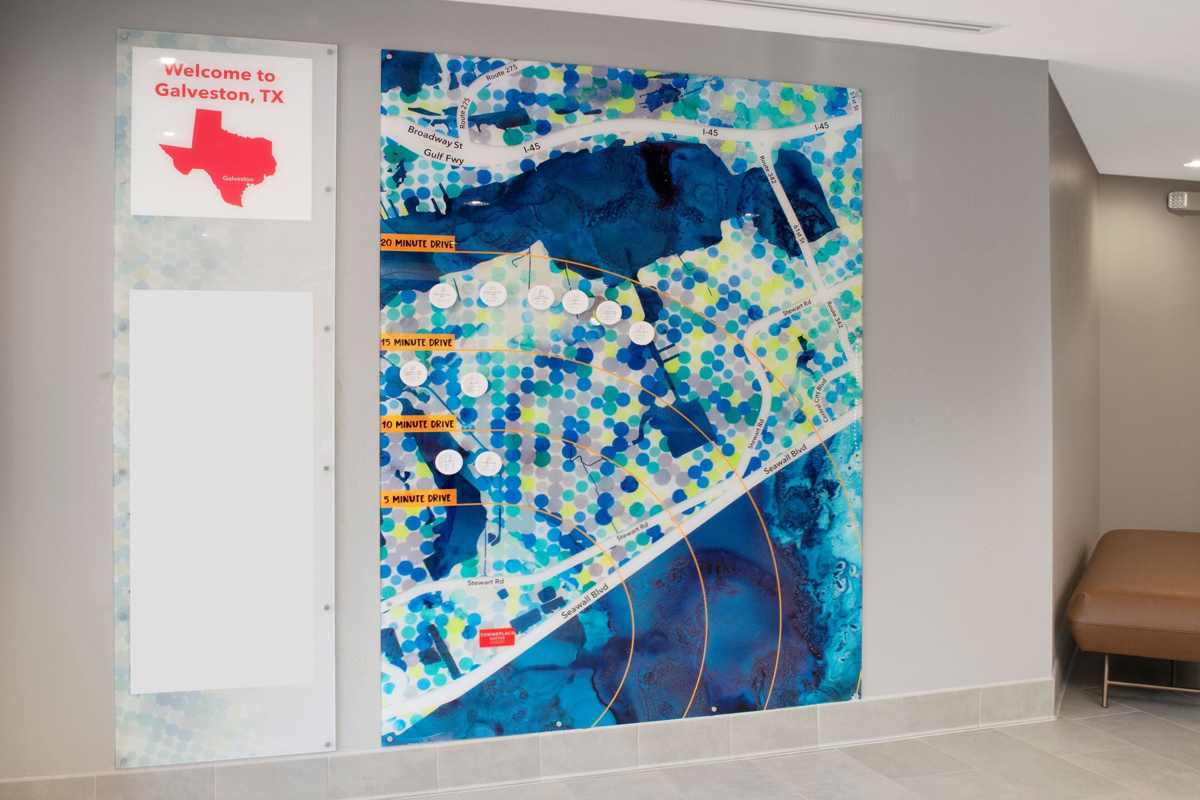 Een kaart van Galveston, TX, met een welkomsteken en een kleurrijke abstracte muurschildering.