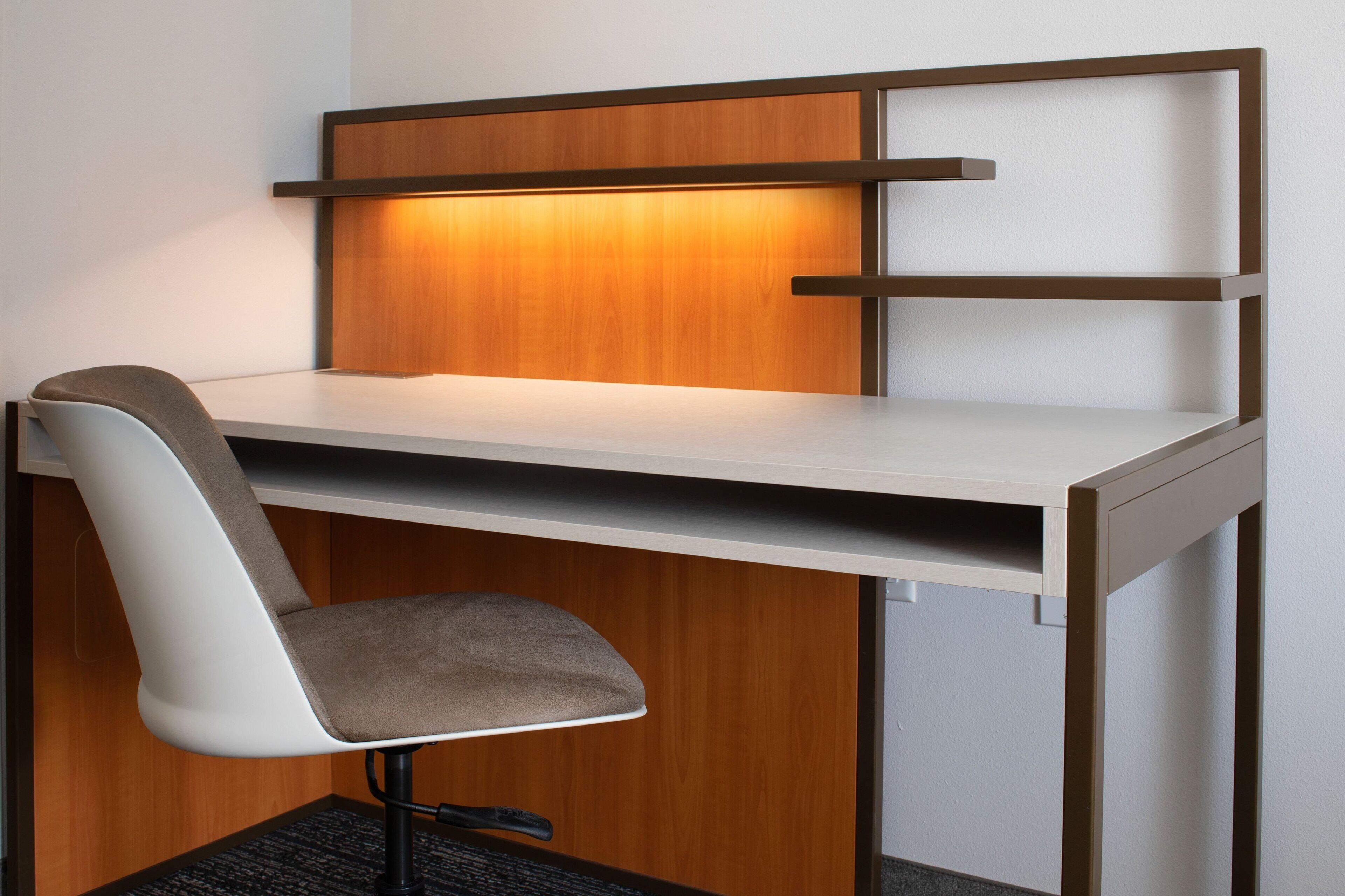 Un bureau moderne avec une chaise, un panneau en bois et une étagère.