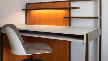 Un bureau moderne avec une chaise, un panneau en bois et une étagère.