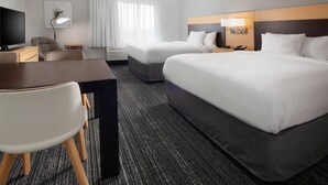 A hotel room with two beds, a desk, a chair, a TV, and a lamp. - TownePlace Suites by Marriott Galveston Island (Galveston)