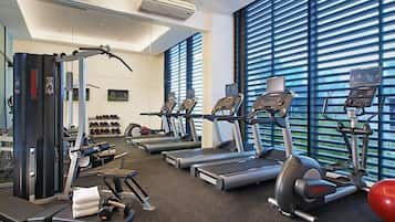 A gym with treadmills, elliptical machines, and weightlifting equipment.