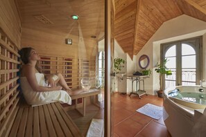 Un sauna de madera con banco, cerramiento de vidrio y ventana visible.