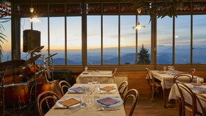 A restaurant with a mountain view, wooden interior, and tables set for dining. - Bellavista Boutique Hotel (Brunate)